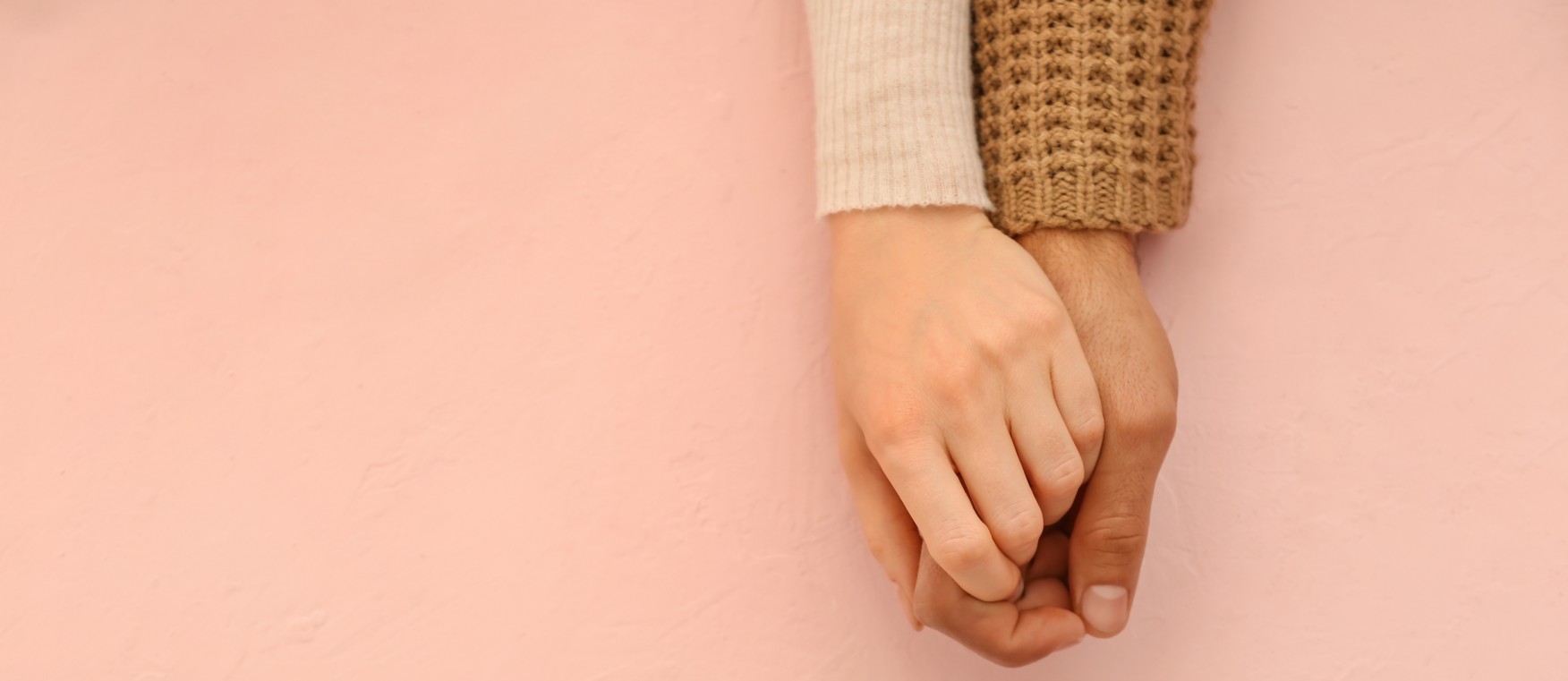 Loving young couple holding hands on color background